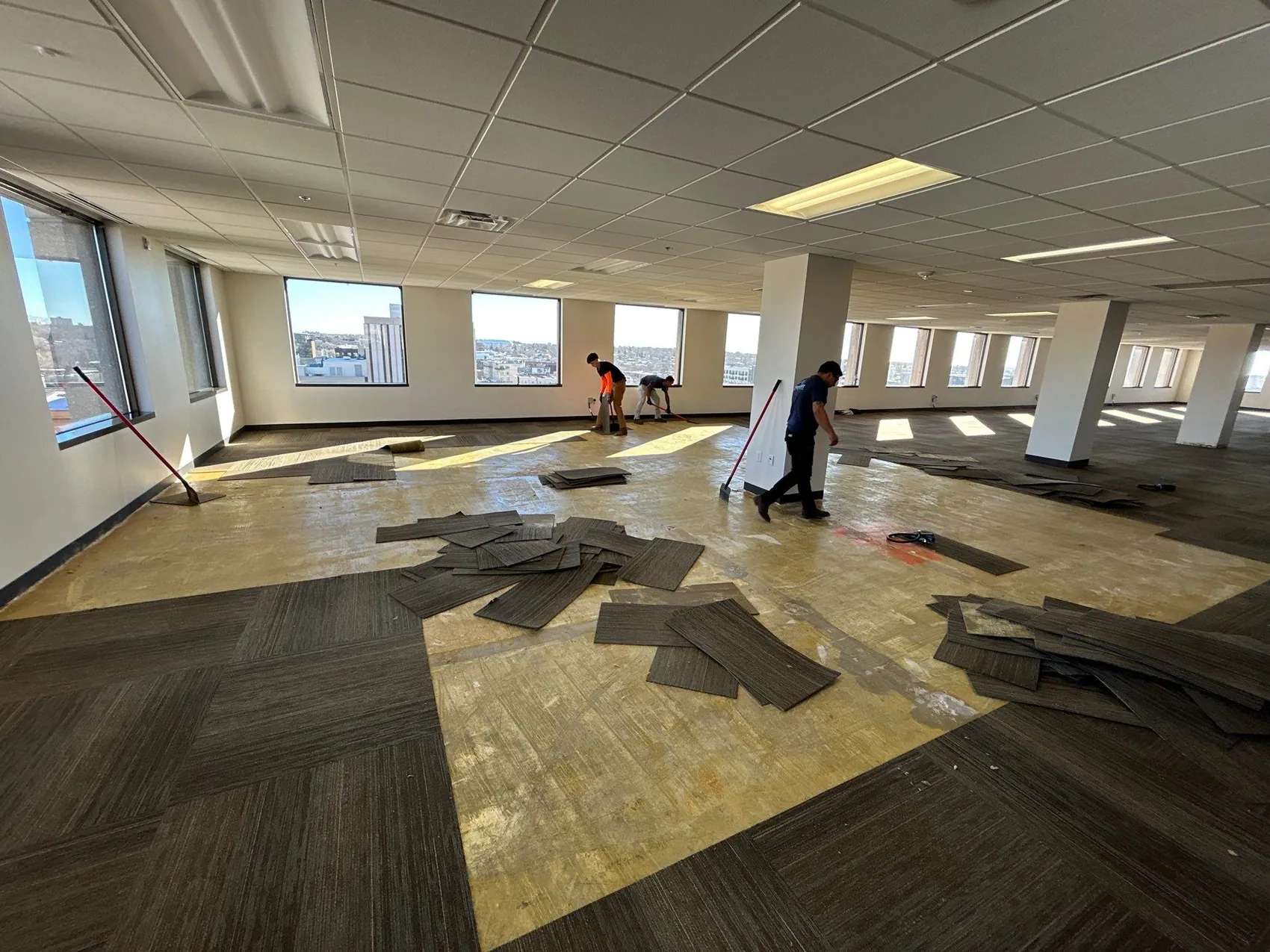 Restoration crew working an expansive commercial office floor with the carpet pulled