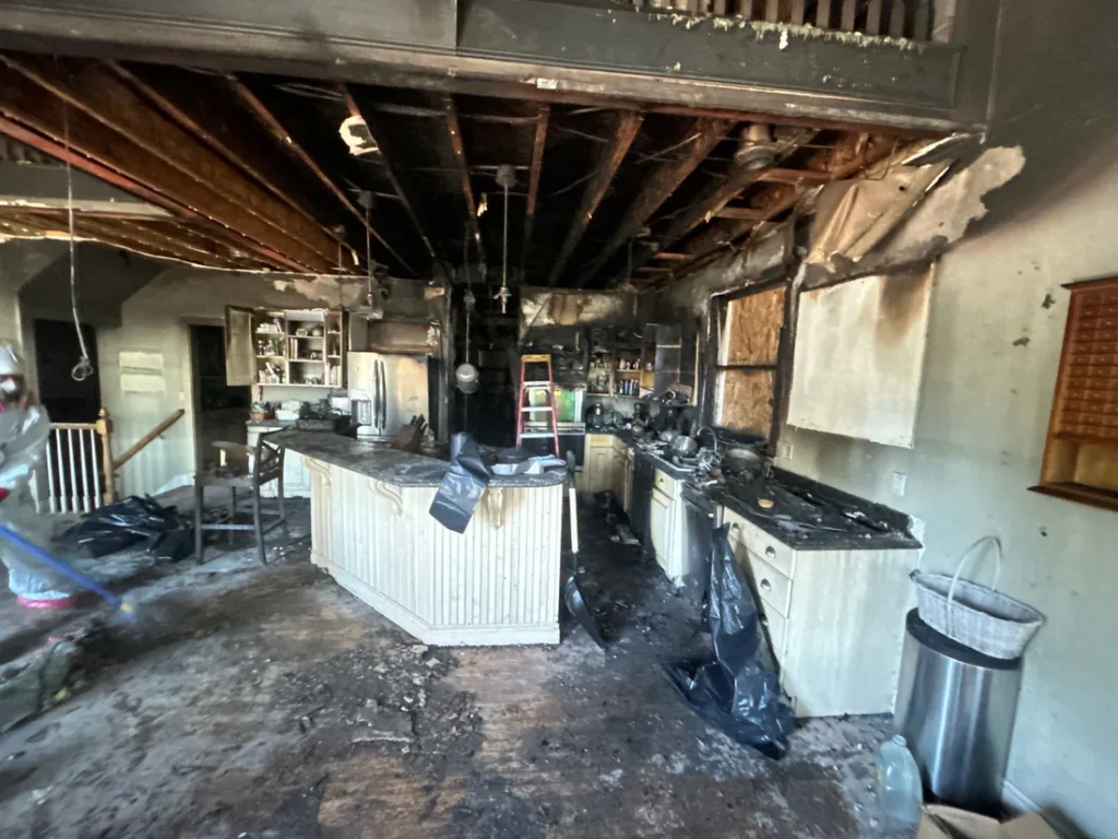 Fire and smoke damage in a kitchen with charred ceiling and cabinets