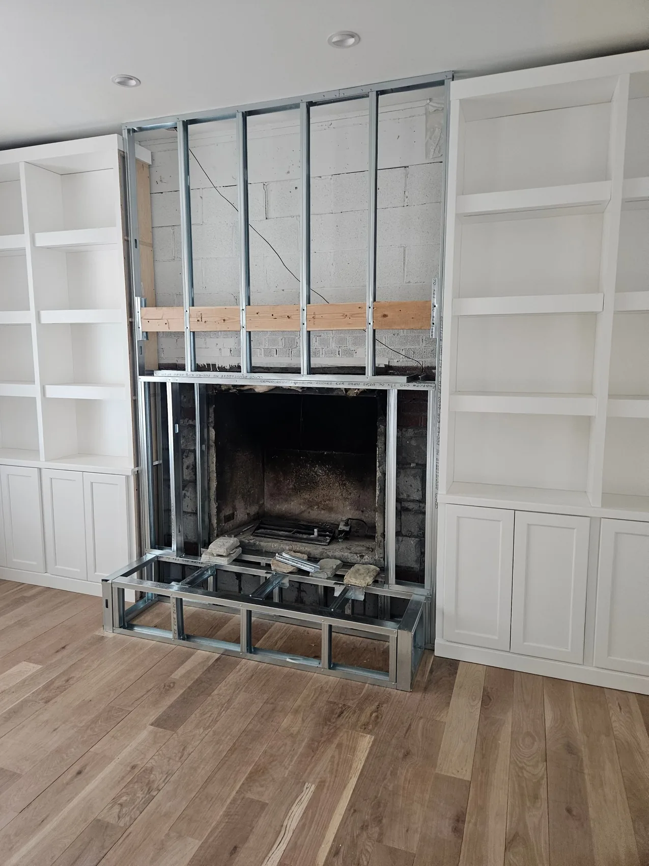Rebuilding a fire-damaged living room, new framing around the fireplace with finished built-ins alongside