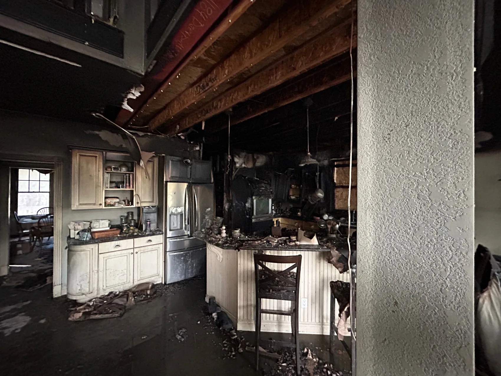 Interior room coated in soot and smoke residue after a house fire