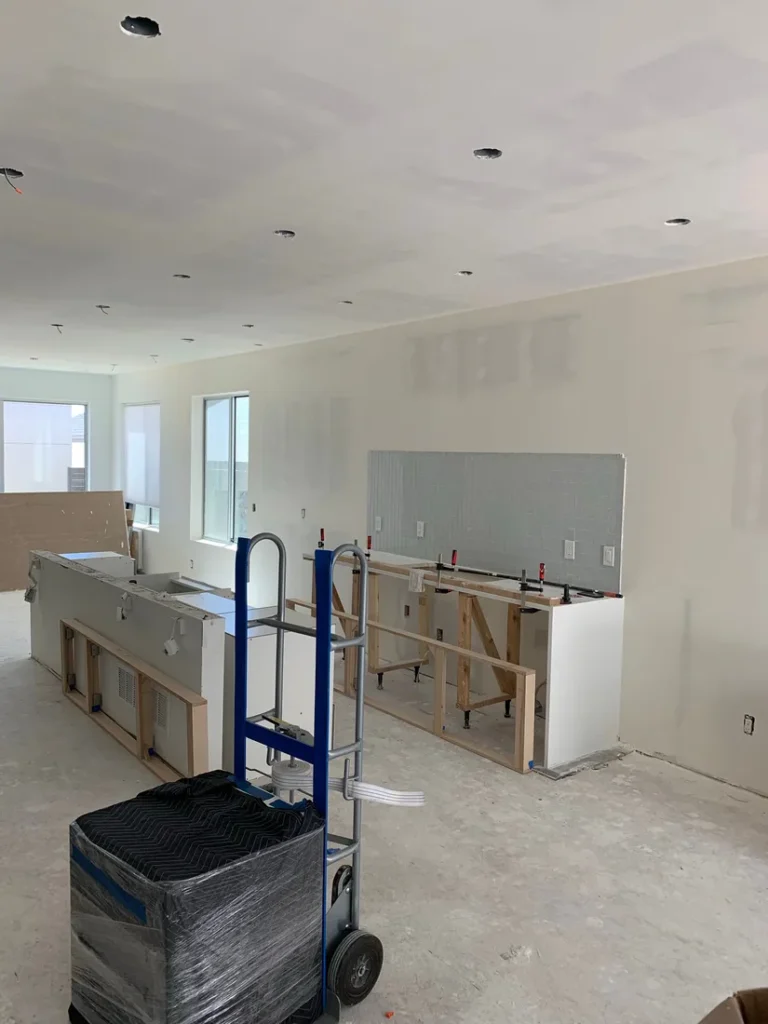 Kitchen reconstruction in progress with new drywall and cabinets after damage