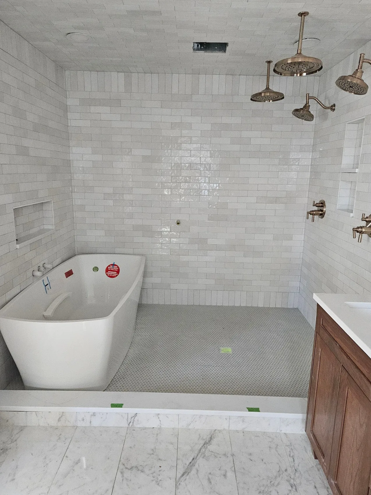 Finished bathroom with a freestanding tub and tiled shower after reconstruction