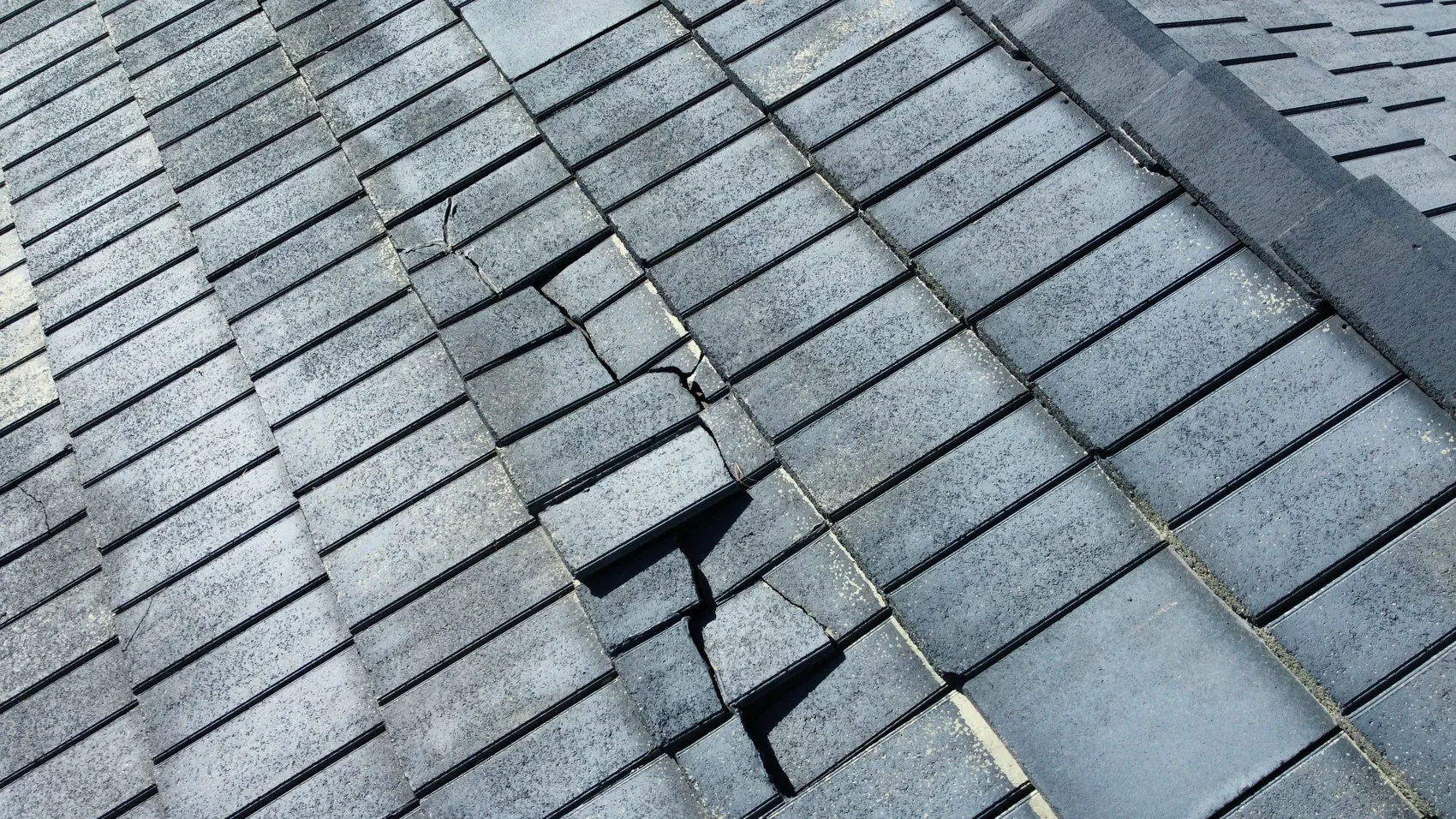 A cracked roof tile found during a close-up Colorado roof inspection