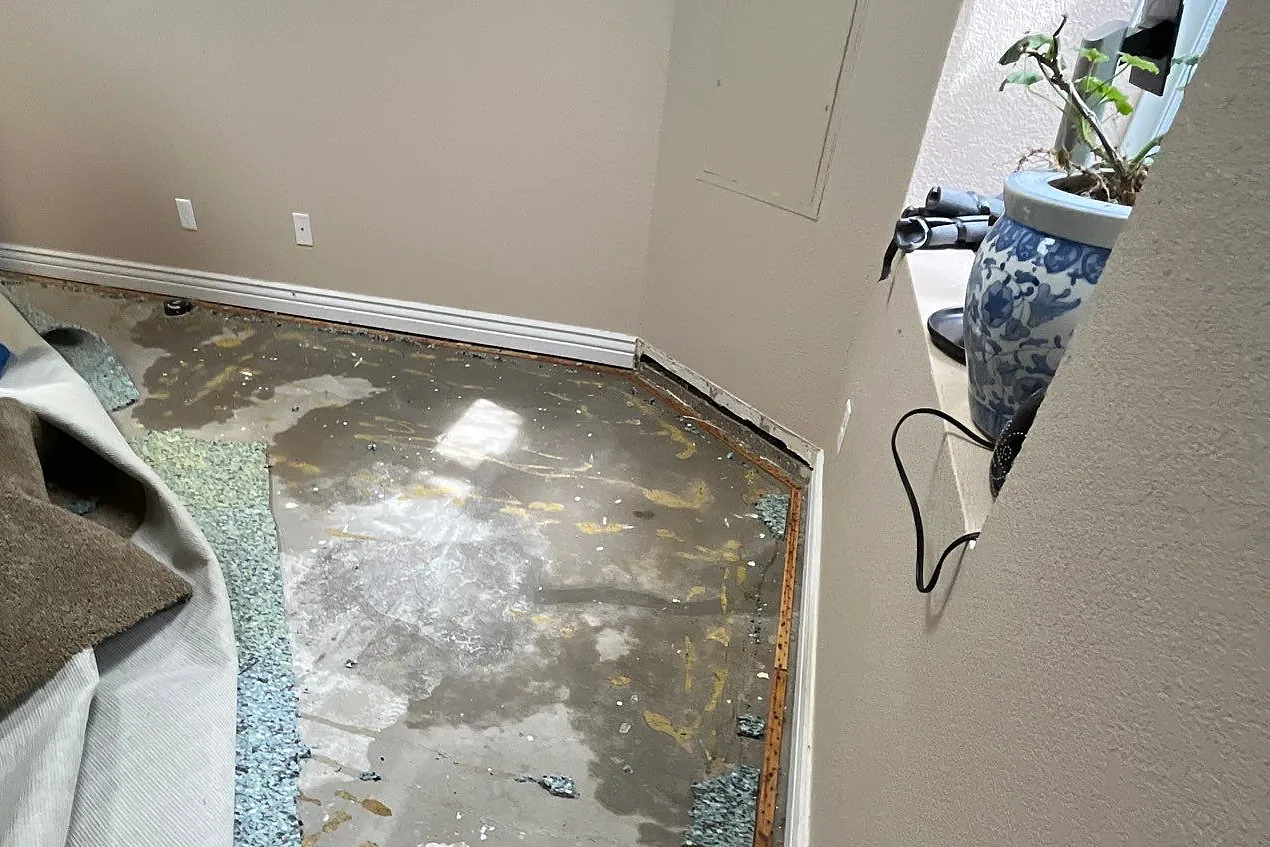 Carpet and pad removed to expose the concrete subfloor after a sewage backup