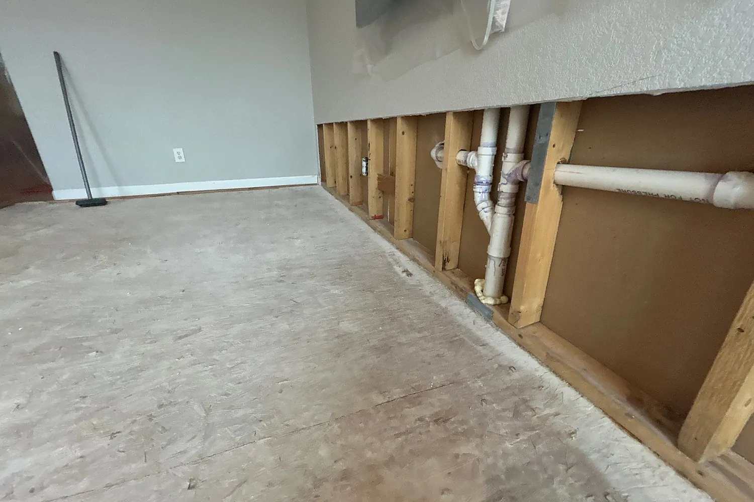 Drywall removed to exposed framing and plumbing with the area cleaned for disinfection