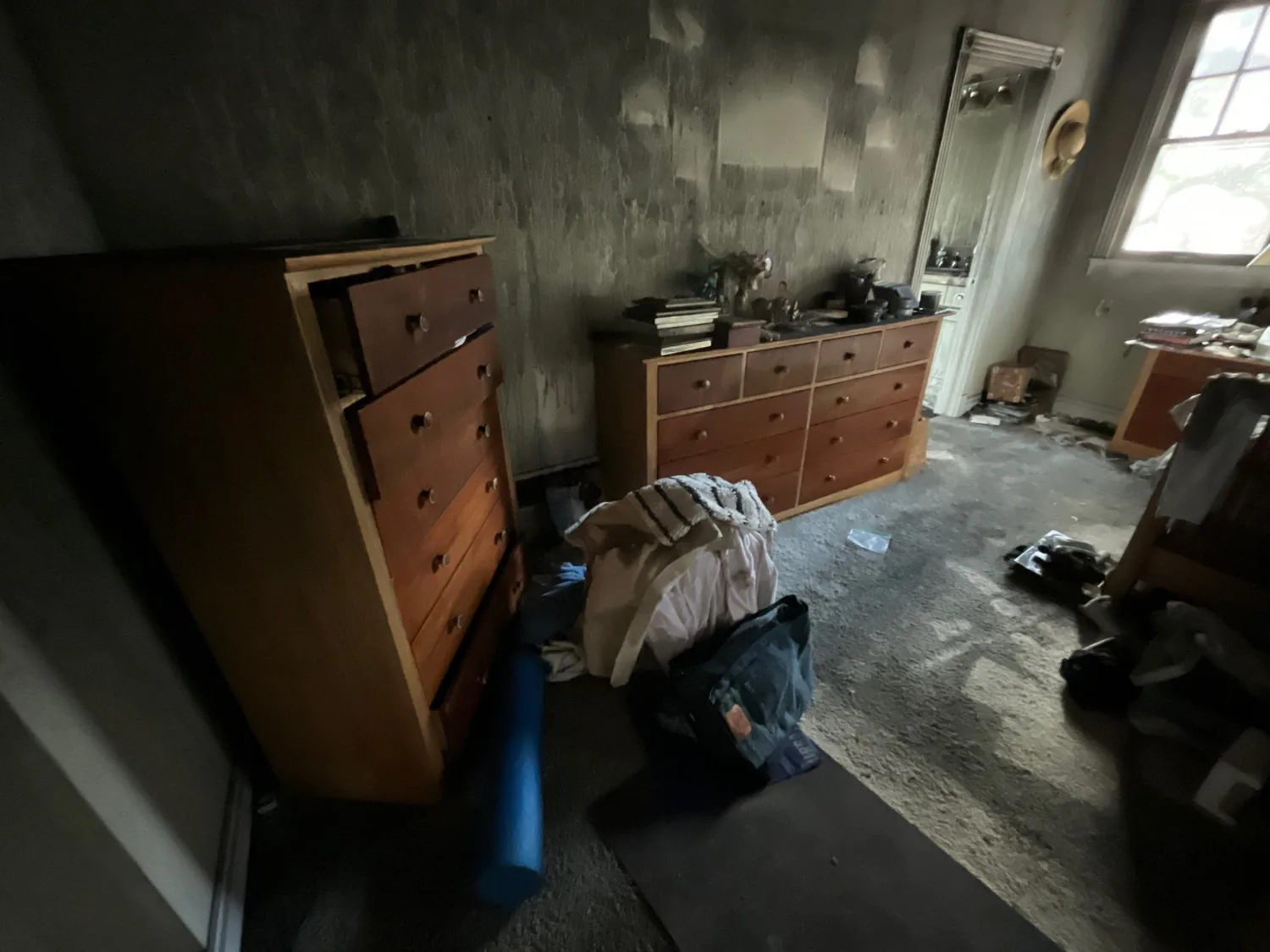 A smoke-damaged room with sooted cabinets and contents before cleaning