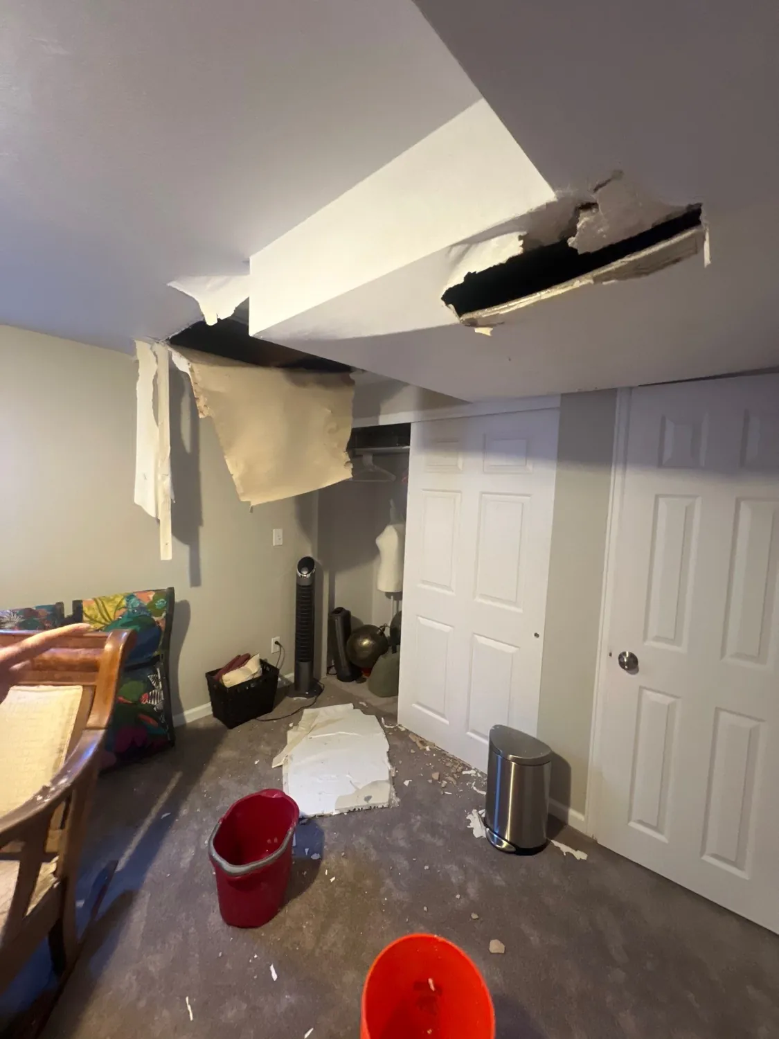 Ceiling collapsed and drywall fallen from water damage, debris and buckets on the floor