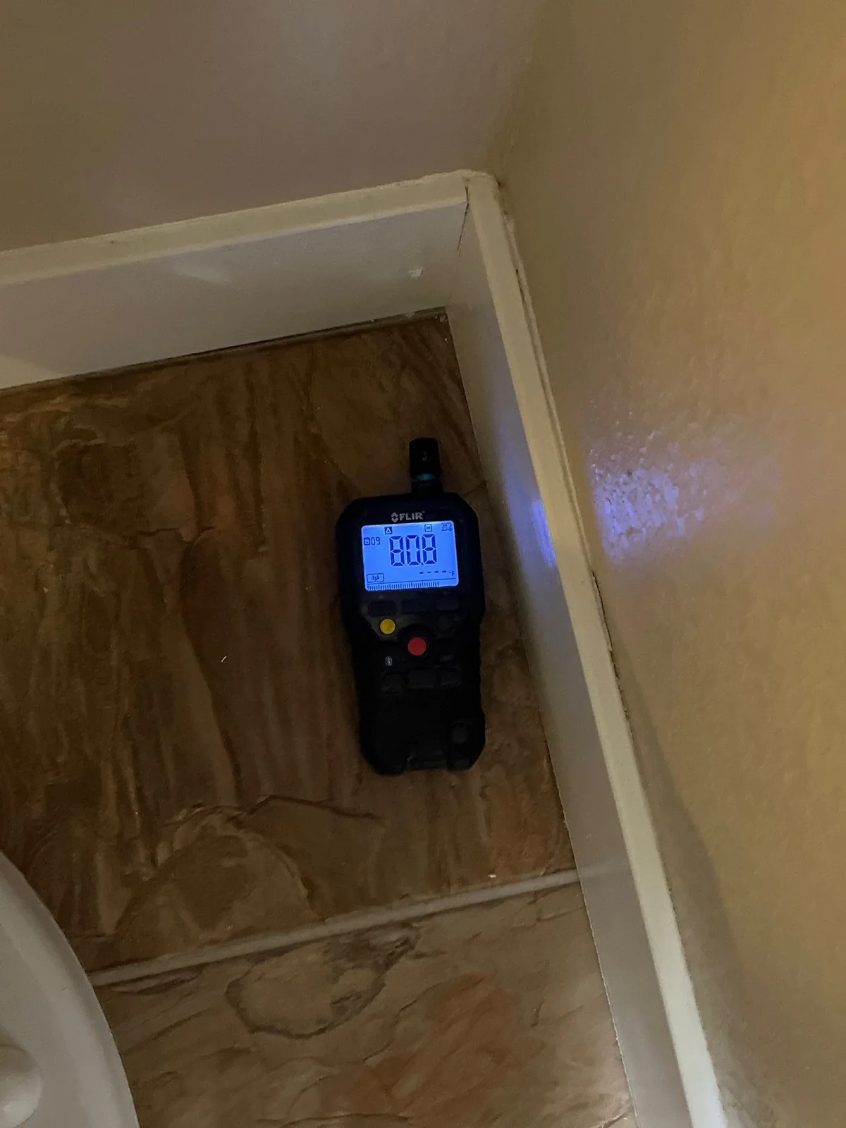 Moisture meter checking a wall during water damage moisture mapping