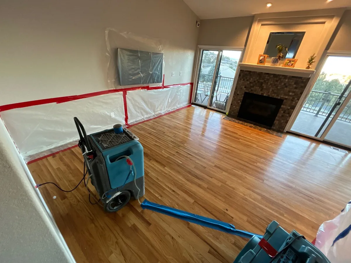 Professional containment barriers and a dehumidifier set up in a living room during an insurance-claim water damage restoration