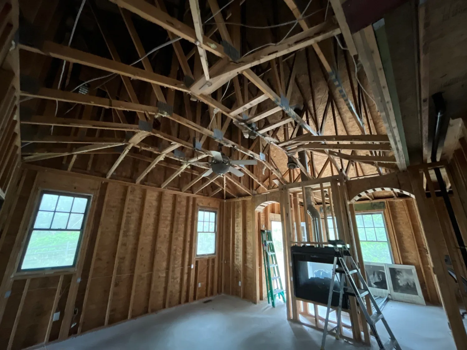 Vaulted great room stripped to wood framing and rafters during reconstruction