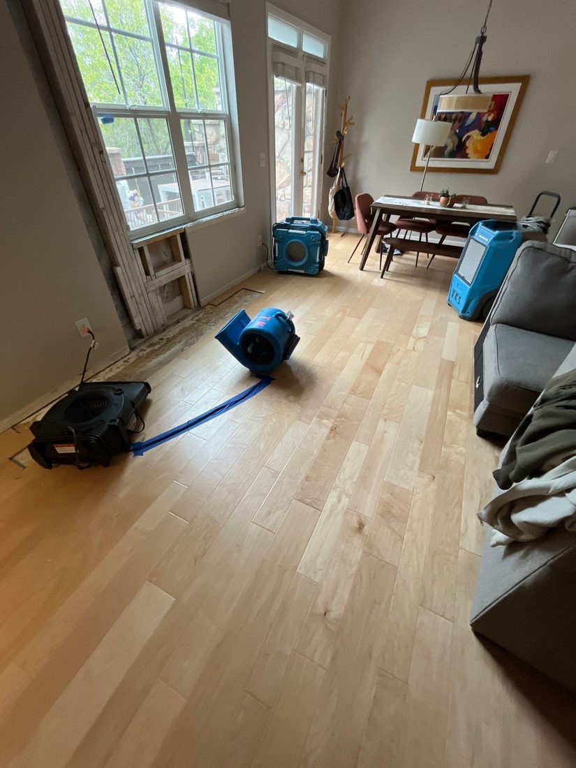 Branded air movers drying a water-damaged Colorado living room