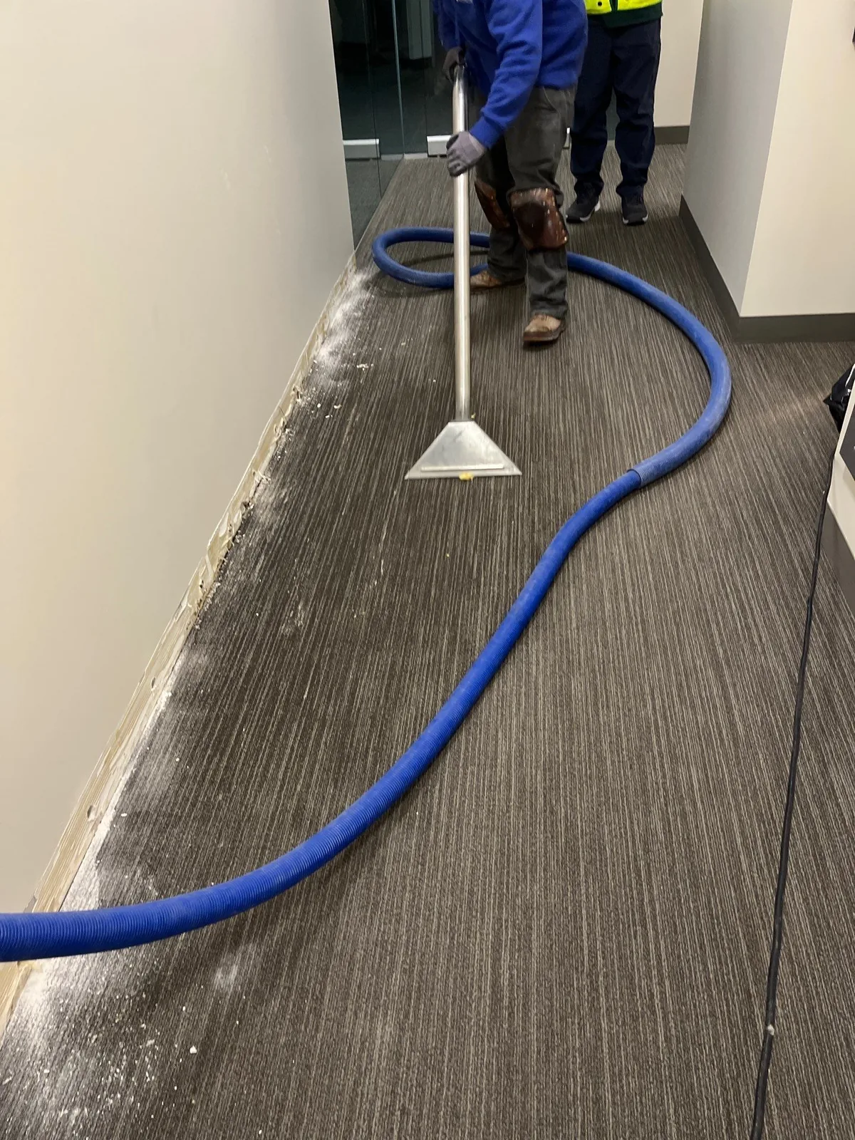 Technician extracting water from saturated carpet during water damage cleanup