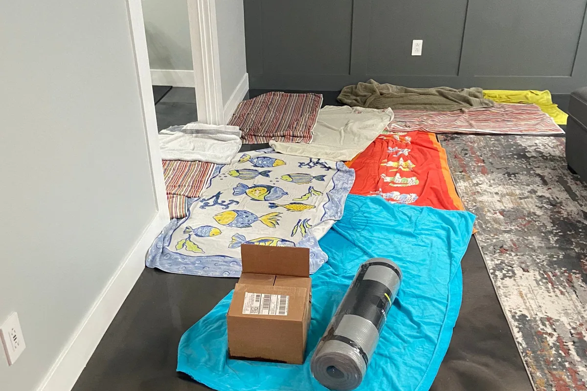 Household beach towels laid across a floor to soak up sewage water before professional cleanup