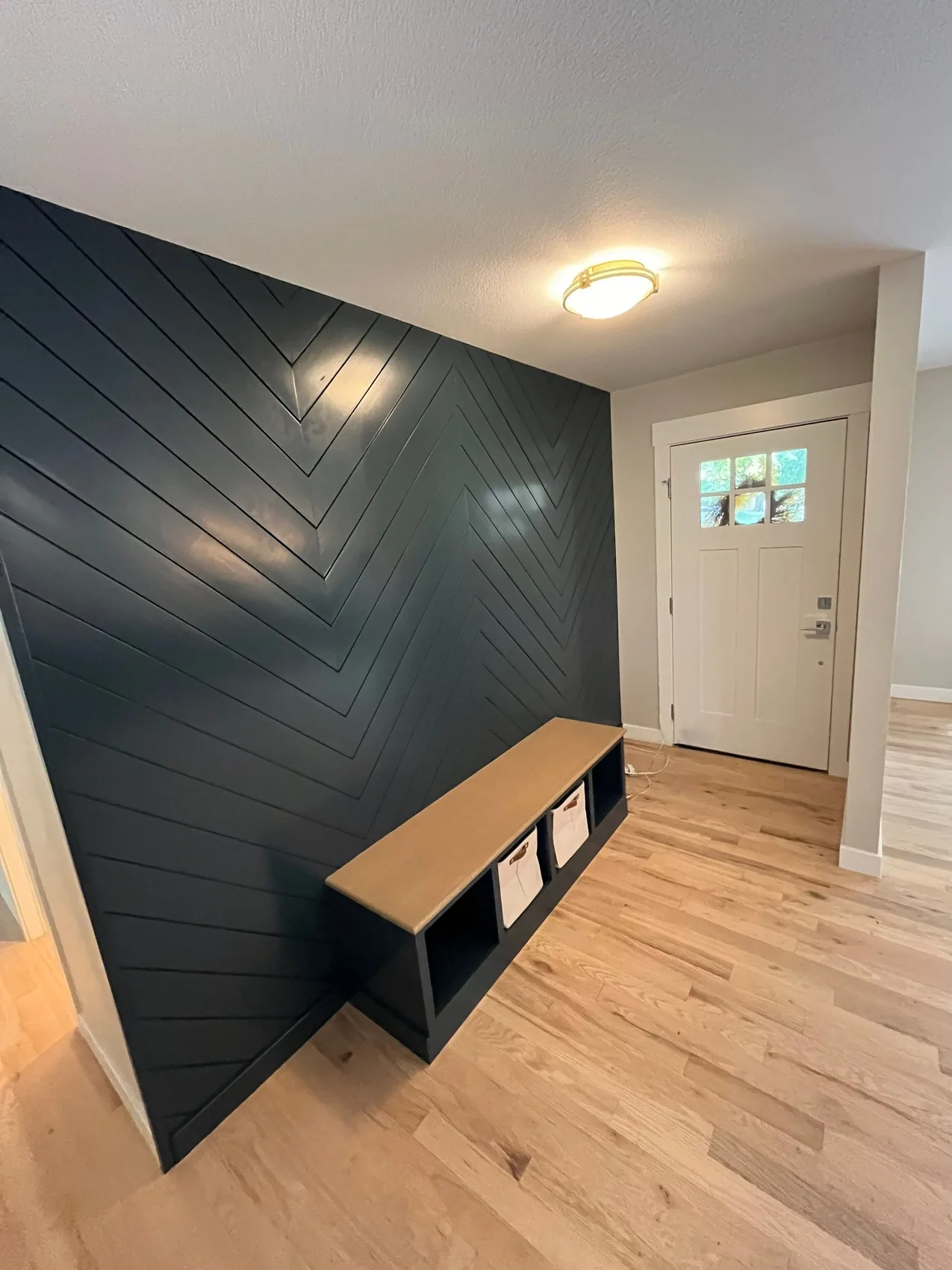 Finished entryway rebuild with a wood accent wall and new flooring by the team that cleaned the smoke