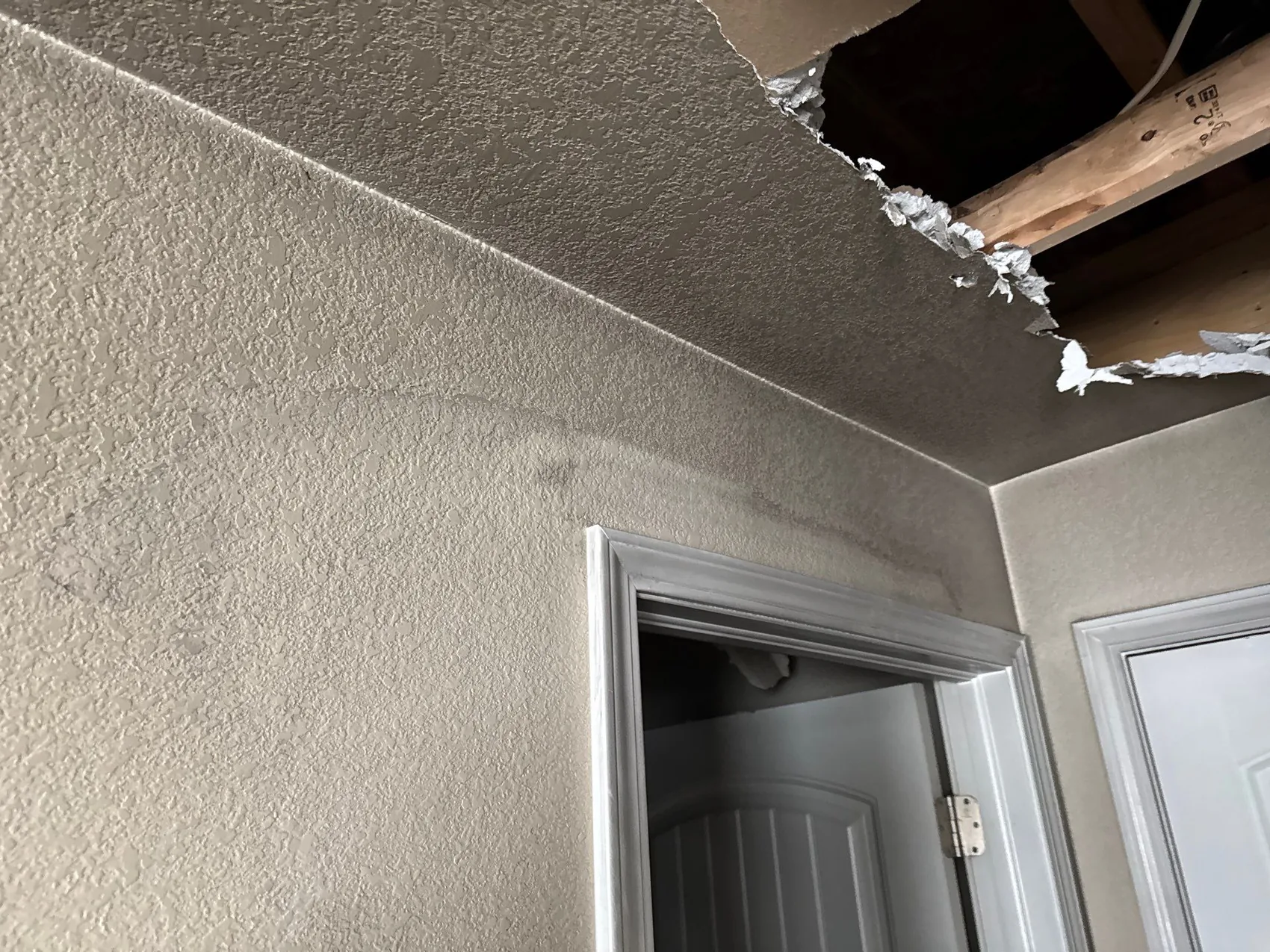 Soot-stained wall and ceiling opened where the fire department cut in, exposing the cavity