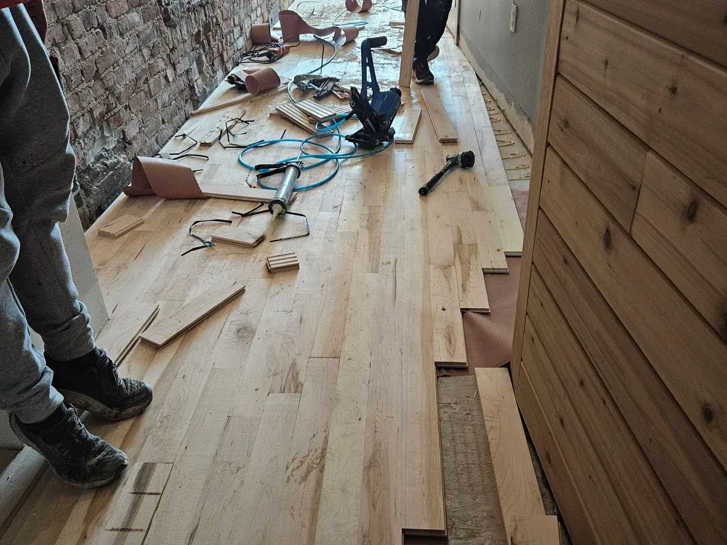 New hardwood flooring being installed during the rebuild phase after water damage
